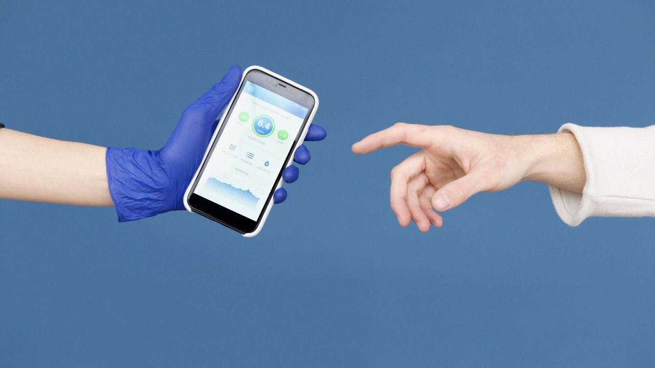 Una mano offre uno smartphone a un'altra — quale telefono comprare