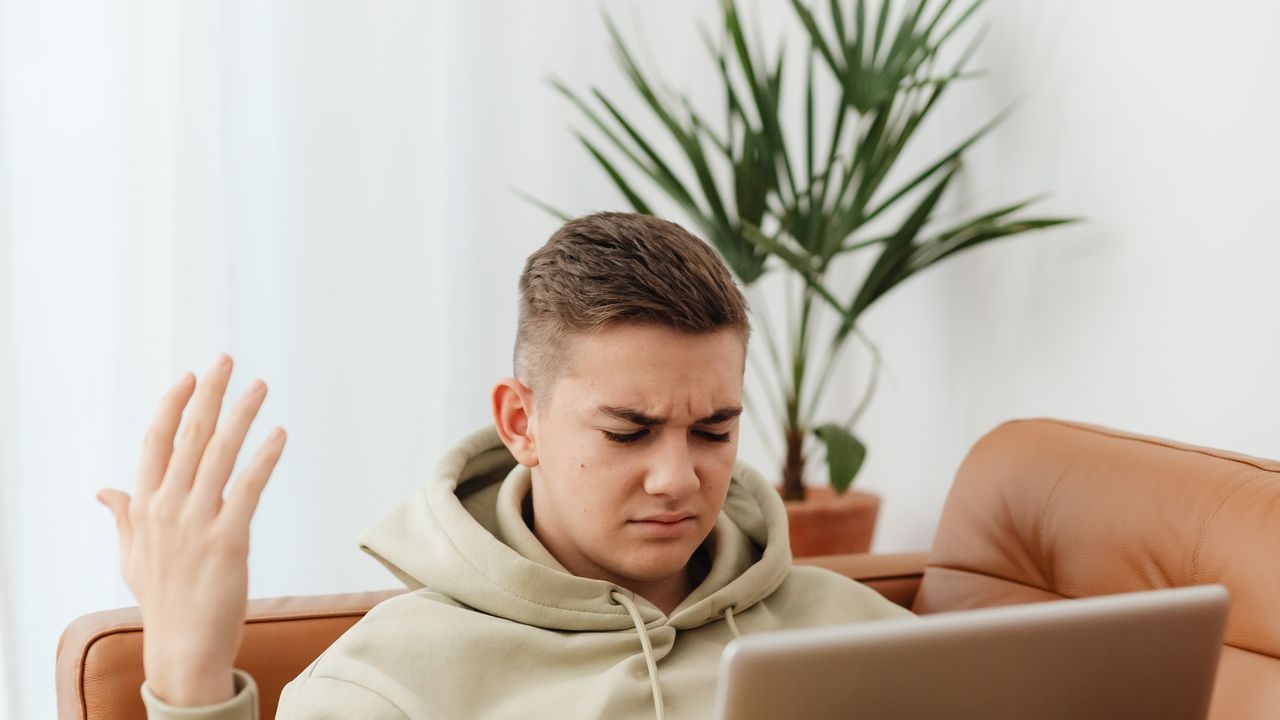 A frustrated person looking at a slow laptop