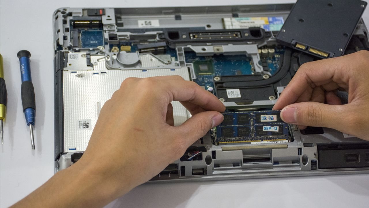 A technician installing an SSD inside an open laptop — K2J Tech upgrade service