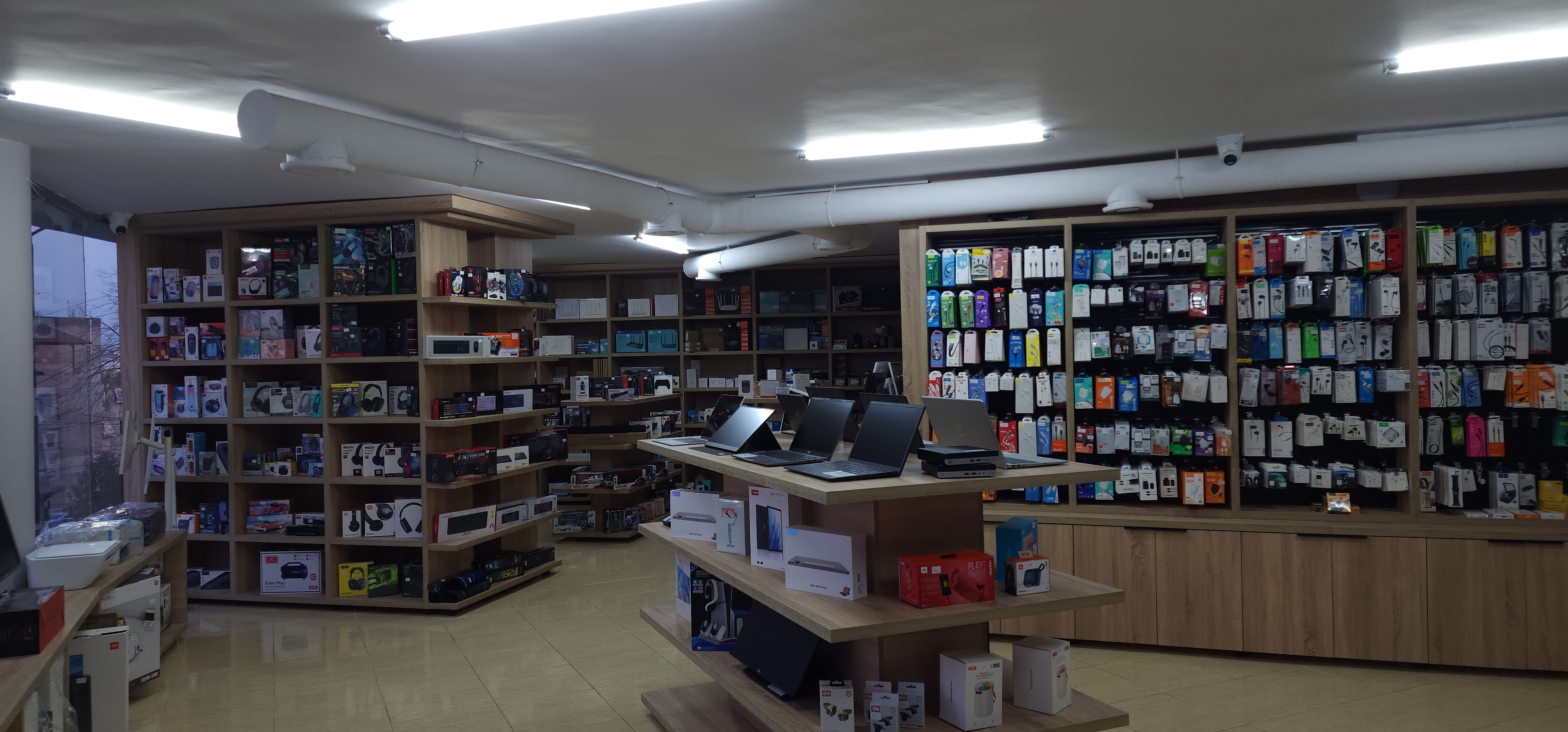 Inside K2J Tech store showing laptops and accessories on display